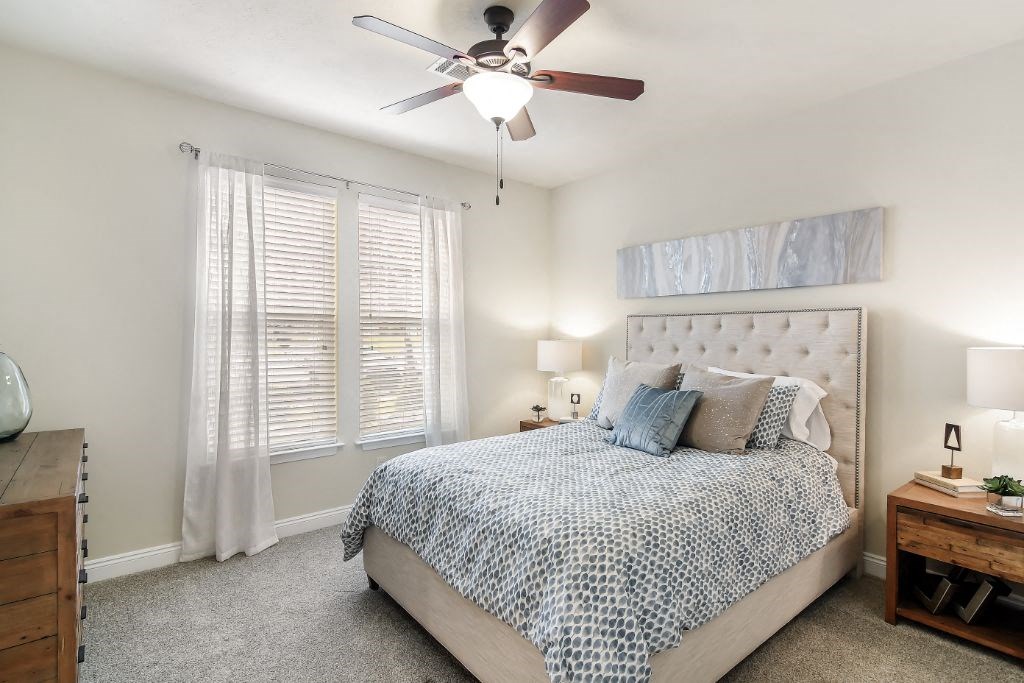 a bedroom with a bed and a ceiling fan