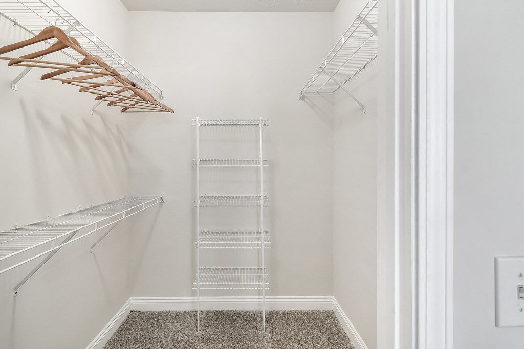 a walk in closet with white walls and a wire closet organizer at Charleston Apartment Homes, Mobile, AL 36695