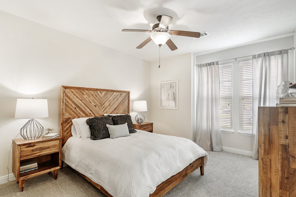 a bedroom with a bed and a ceiling fan at Charleston Apartment Homes, Alabama