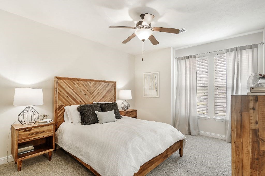 a bedroom with a bed and a ceiling fan