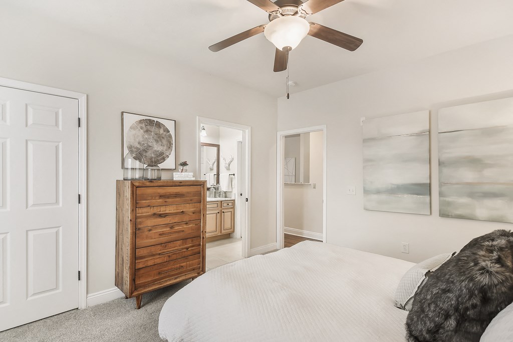a bedroom with a bed and a ceiling fan at Charleston Apartment Homes, Mobile, Alabama