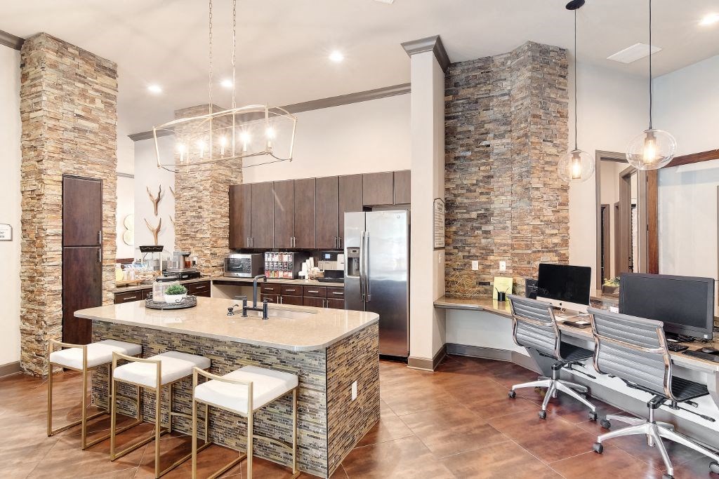 a kitchen with a large island and a desk with a computer  at Kingston Crossing Apartment Homes, Louisiana