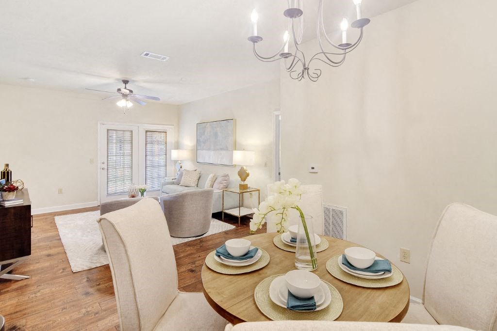 a living room and dining room with a table and chairs at Summit of Shreveport Apartment Homes, Shreveport, Louisiana