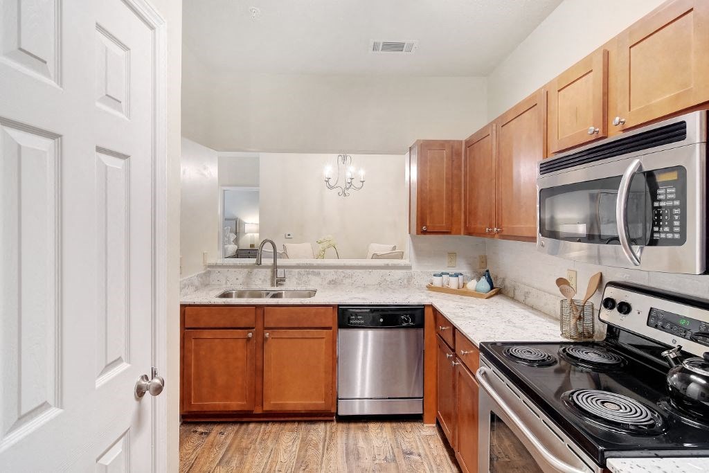 a kitchen with wooden cabinets and stainless steel appliances at Summit of Shreveport Apartment Homes, Shreveport, Louisiana