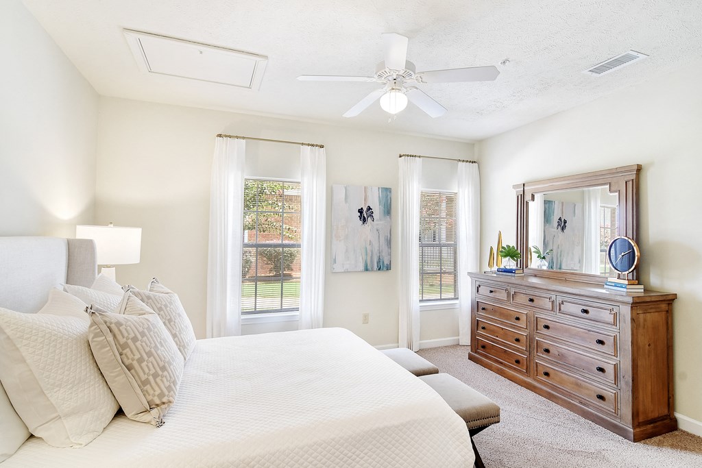 a bedroom with a large bed and a dresser at Summit of Shreveport Apartments, Shreveport, Louisiana
