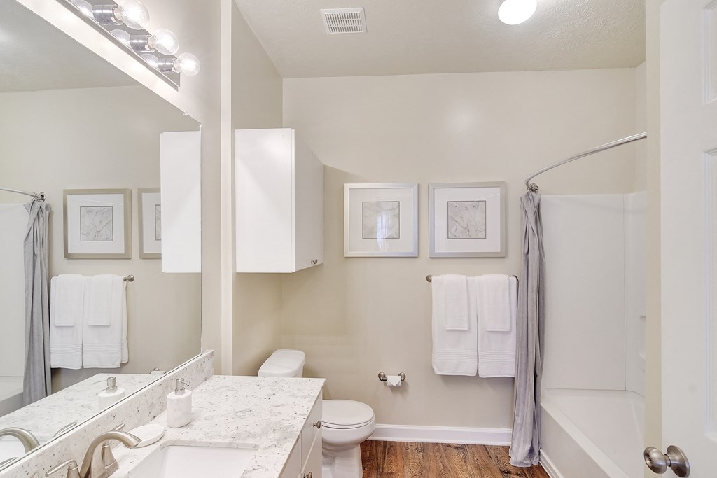 a bathroom with a shower toilet and sink and a mirror at Summit of Shreveport Apartments, Louisiana 71105