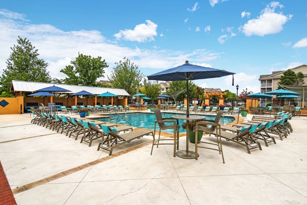 a swimming pool with chaise lounge chairs and umbrellas at Summit of Shreveport Apartment Homes, Shreveport, 71105