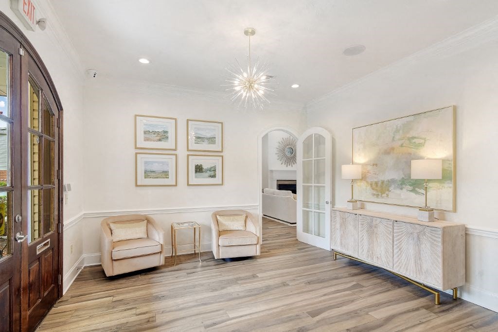 a living room with white walls and a chandelier at Summit of Shreveport Apartment Homes, Shreveport