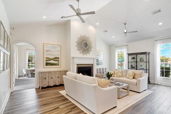 A spacious living room with a fireplace and a large painting on the wall at Summit of Shreveport Apartments, Shreveport, LA