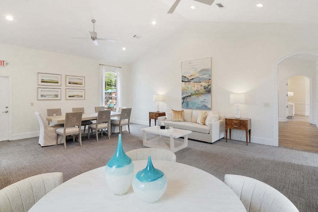 a living room with a white couch and a table with two vases on top of it at Summit of Shreveport Apartment Homes, Shreveport, LA