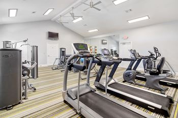 A gym with treadmills, elliptical machines, and other exercise equipment at Summit of Shreveport Apartment Homes in Shreveport, LA
