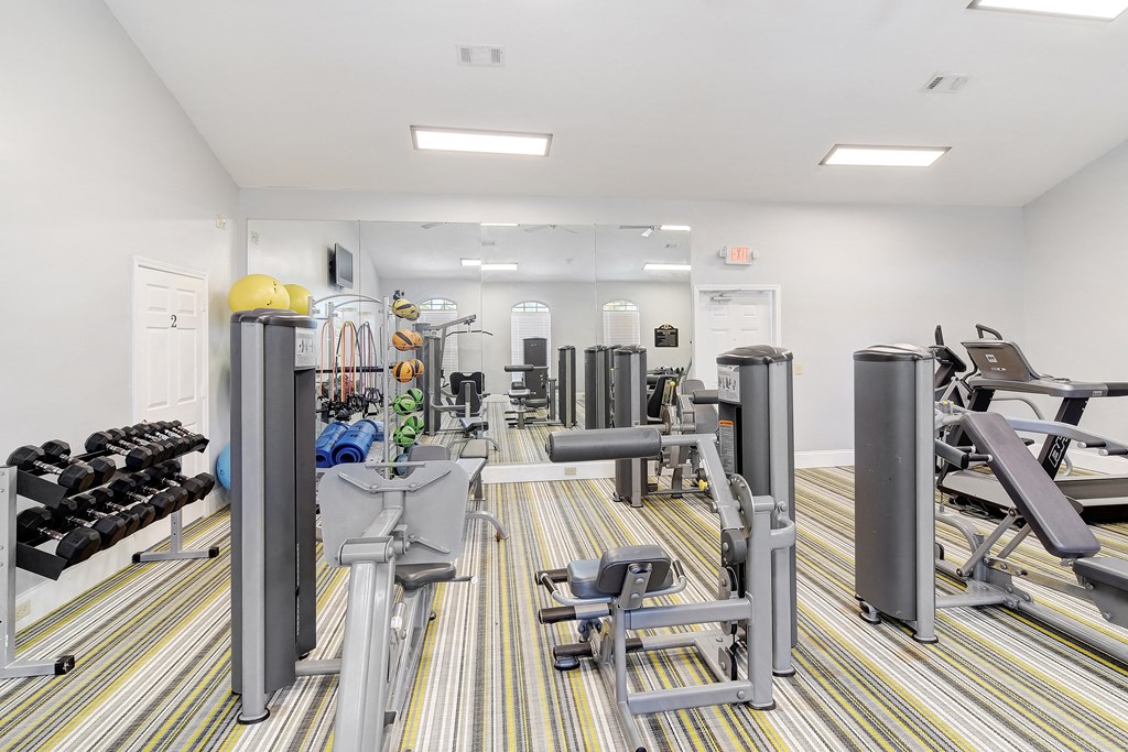 a gym with cardio machines and weights on the floor at Summit of Shreveport Apartments, Louisiana