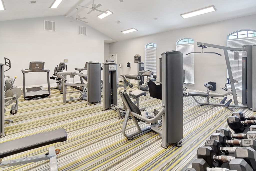 a fitness room with cardio machines and weights on the floor at Summit of Shreveport Apartments, Shreveport, LA