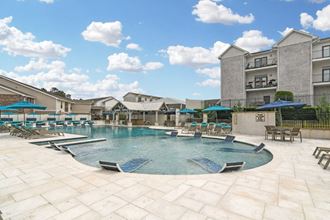 a resort style pool with lounge chairs and umbrellas at the villas at falling waters