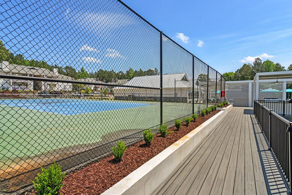 a tennis court is enclosed by a chain link fence at The Woodlands Apartment Homes, Mississippi 39301