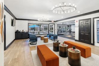 a lobby with orange couches and blue chairs - Photo Gallery