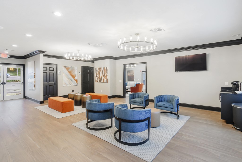 a lobby with chairs and tables and a television at The Woodlands Apartment Homes, Meridian