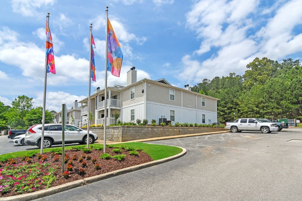 a large white building with flags in front of it at The Woodlands Apartment Homes, MS, 39301
