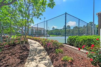 Garden pathway with a fence and flowers at Highpointe Apartment Homes, Mississippi