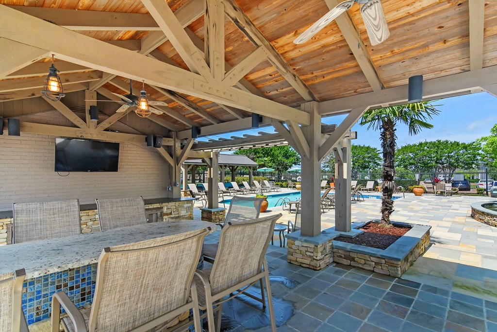 a resort style patio with a bar and a pool at Highpointe Apartment Homes, Mississippi