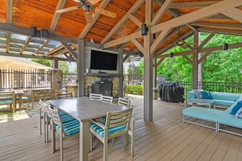 A wooden deck with a TV and seating area at Highpointe Apartment Homes, Brandon, MS
