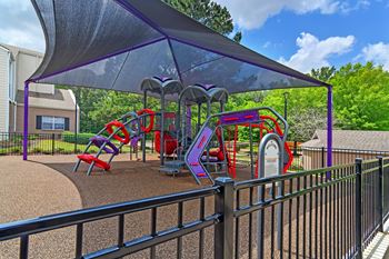 A covered playground with a slide and climbing areas at Highpointe Apartment Homes, Brandon, Mississippi