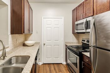 Kitchen with stainless steel appliances and granite countertops at Highpointe Apartment Homes, Brandon, 39042