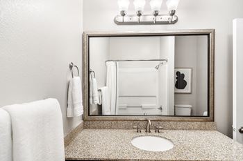 Bathroom with a sink, mirror, and towel at Highpointe Apartment Homes, Brandon, Mississippi