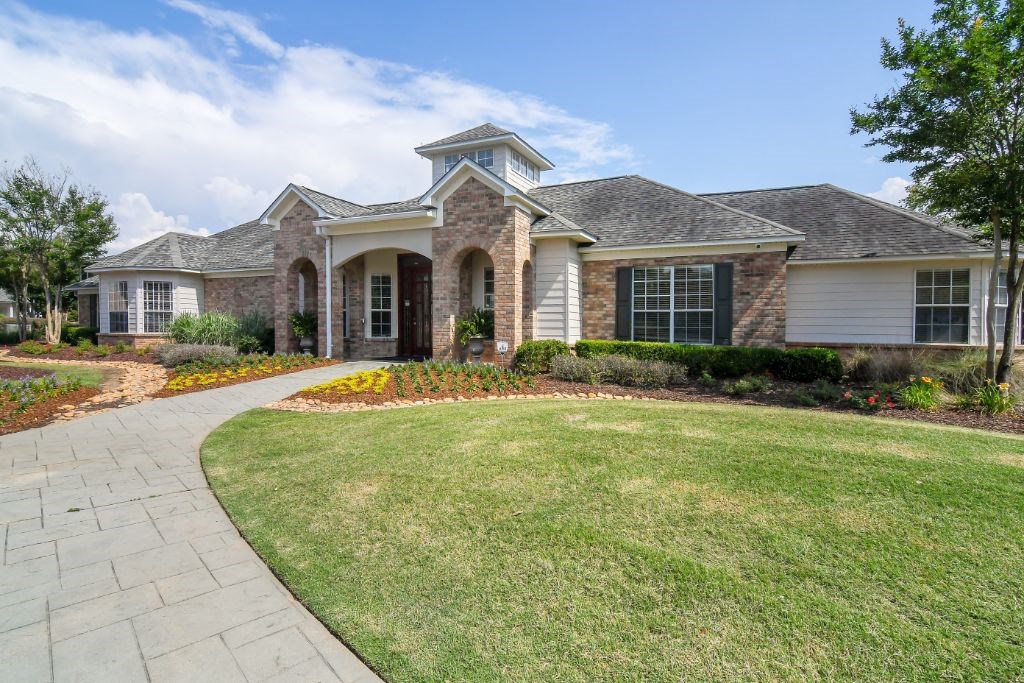 a house with a green lawn and a walkway in front of it at Ashford Place Apartment Homes, Flowood, MS