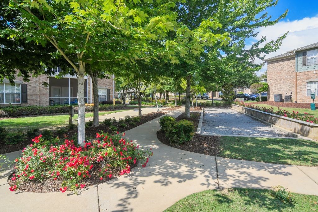 a pathway with trees and flowers on either side of it at Ashford Place Apartment Homes, Flowood, 39232