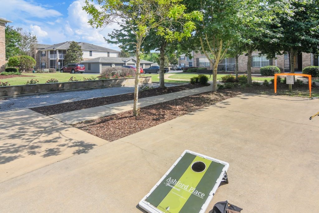 a park with trees and buildings in the background at Ashford Place Apartment Homes, Flowood, MS, 39232