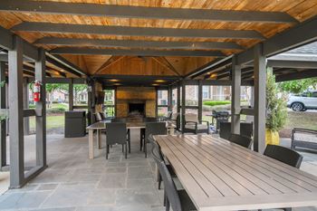 A wooden table is in the middle of a patio at Ashford Place Apartment Homes, Flowood, Mississippi
