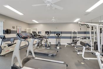 A spacious gym with treadmills, elliptical machines, and other exercise equipment at Ashford Place Apartment Homes, Flowood, MS 39232
