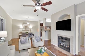 A living room with a fireplace and a television at Ashford Place Apartment Homes, Flowood, 39232