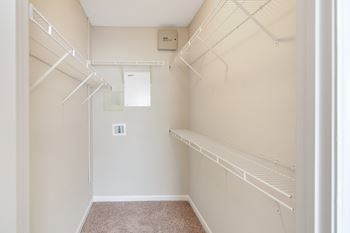 a spacious walk in closet with white rails and shelves at Legacy Apartment Homes in Ridgeland, MS
