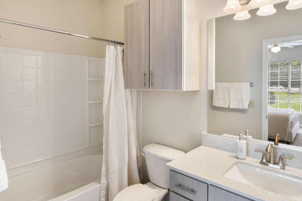 a bathroom with a toilet sink and bathtub  at Legacy Apartment Homes, Ridgeland