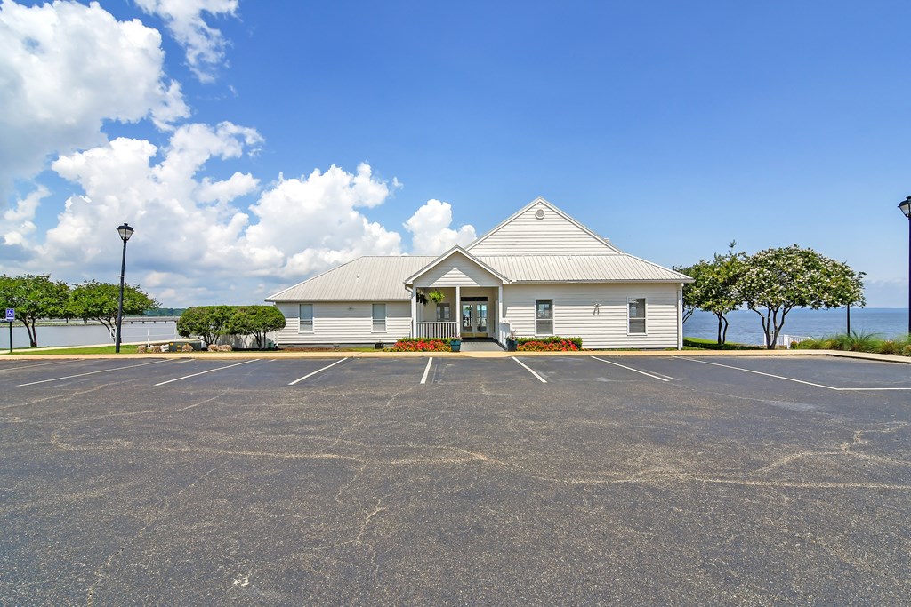an empty parking lot in front of a white building at Lakeshore Pointe Apartment Homes, Mississippi