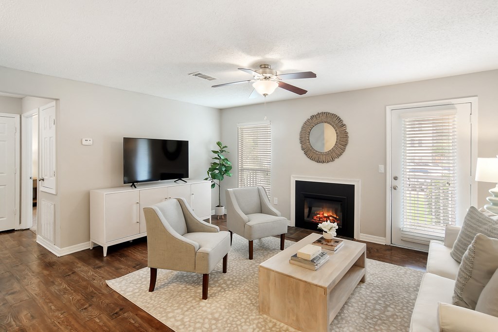 a living room with a fireplace and a ceiling fan at Lakeshore Pointe Apartment Homes, Brandon, 39047
