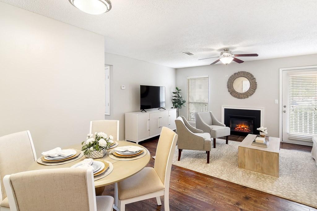 a living room and dining room with a table and chairs and a fireplace at Lakeshore Pointe Apartment Homes, Mississippi