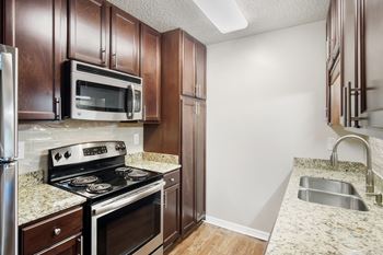 A kitchen with a stove, microwave, and refrigerator  at Lakeshore Pointe Apartment Homes, Brandon