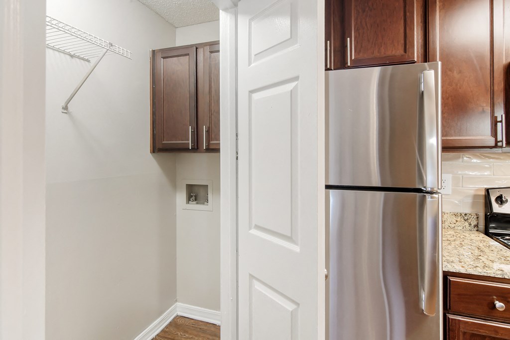 a kitchen with a stainless steel refrigerator and wooden cabinets at Lakeshore Pointe Apartment Homes, Brandon, MS
