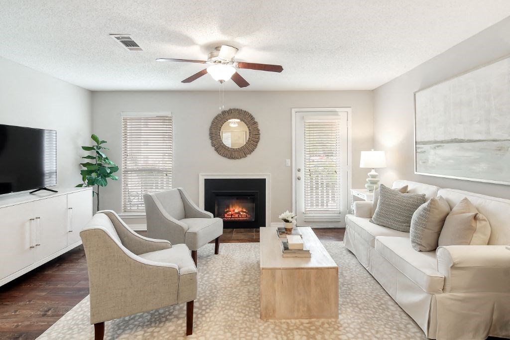 a living room with a fireplace and a ceiling fan at Lakeshore Pointe Apartment Homes, Brandon, MS