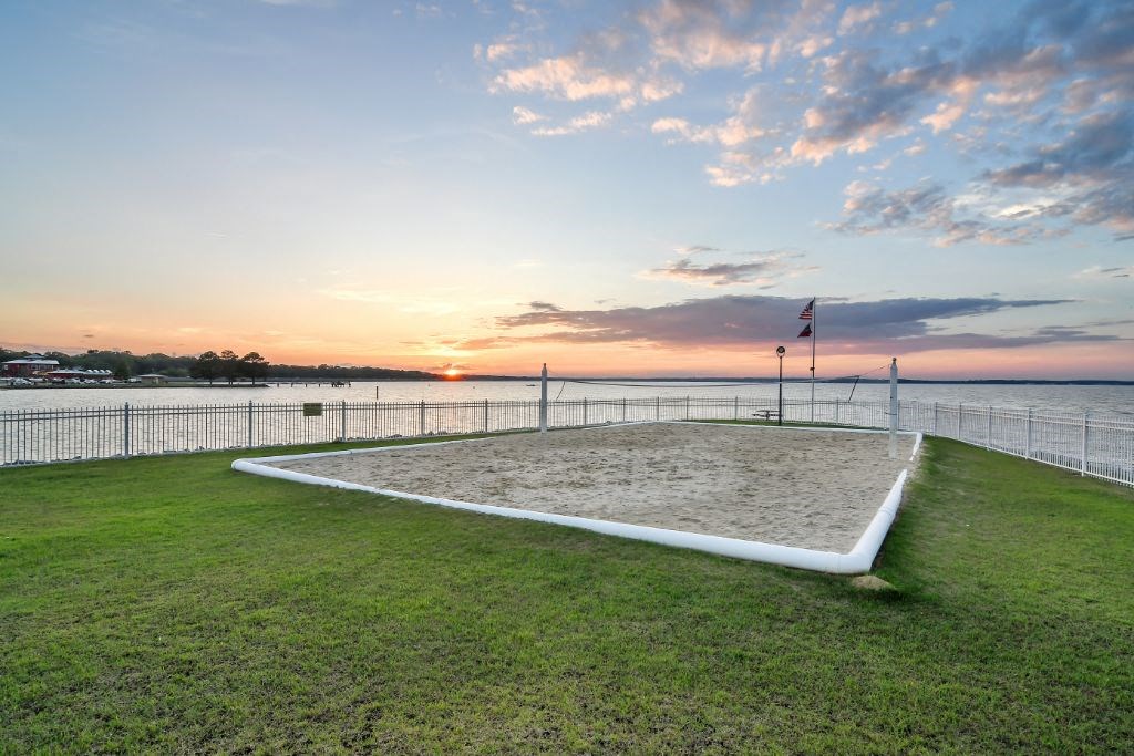 a volleyball court on a grassy lawn with the ocean in the background at Lakeshore Pointe Apartment Homes, Mississippi