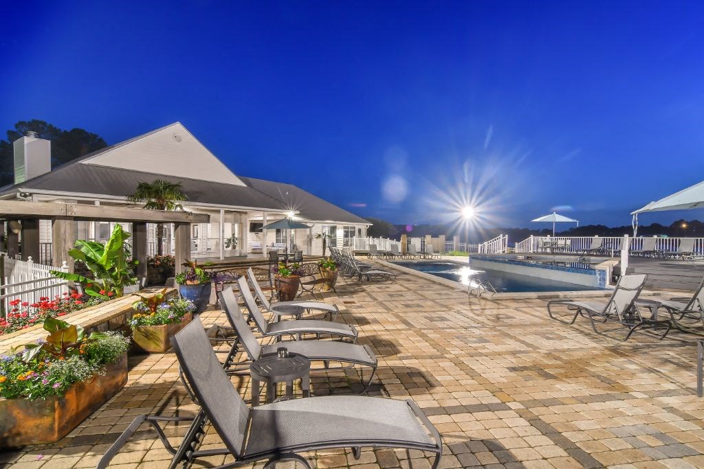 a resort style swimming pool with lounge chairs and sun umbrellas at Lakeshore Pointe Apartment Homes, Brandon, 39047