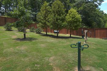 a backyard with trees and sculptures in the grass at The Met Apartment Homes in Hattiesburg, 39402