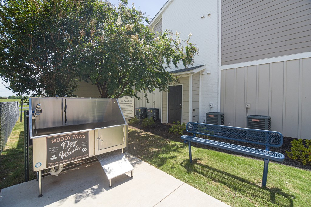 a grill and a bench in front of a building at Reserve of Bossier City Apartment Homes in Bossier City, LA 