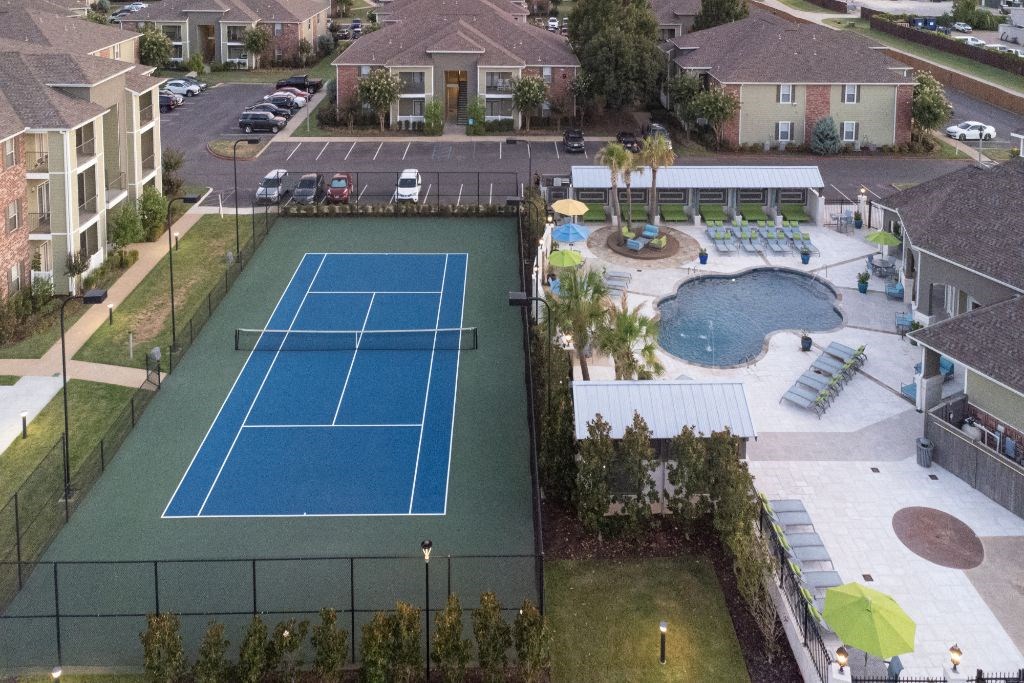an aerial view of a pool and tennis court in a community at Canebrake Apartment Homes, LA