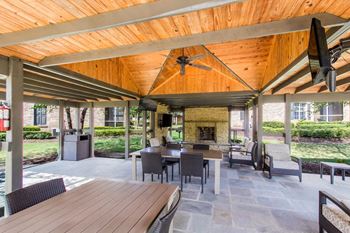 a covered patio with a fireplace and a wooden ceiling at Ashford Place Apartment Homes, Mississippi