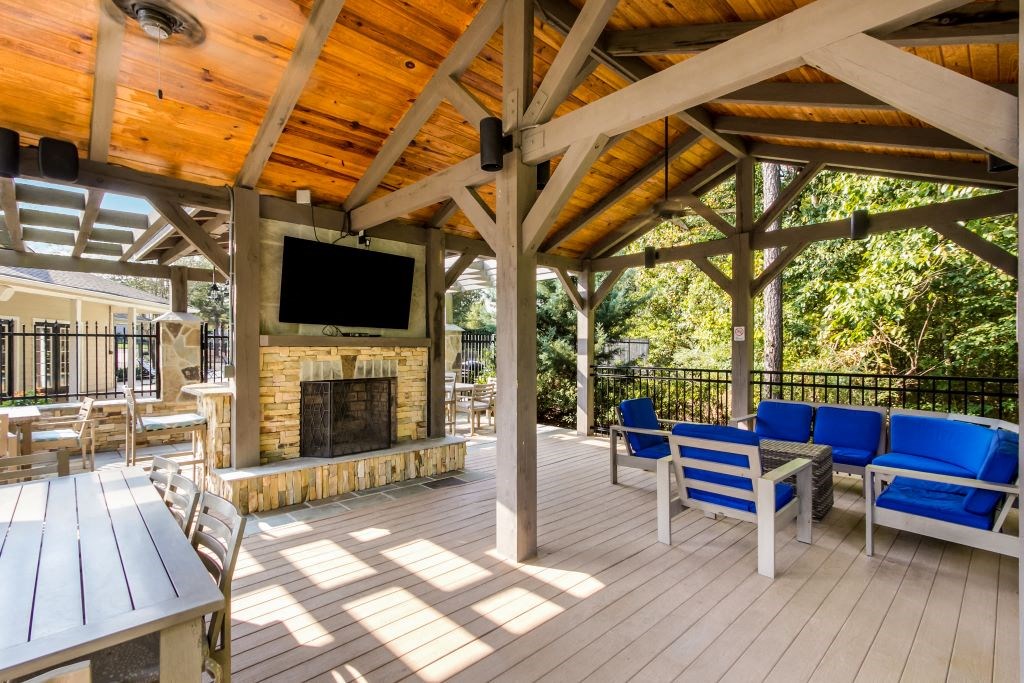 a covered patio with a fireplace and a tv  at Highpointe Apartment Homes, Brandon, 39042