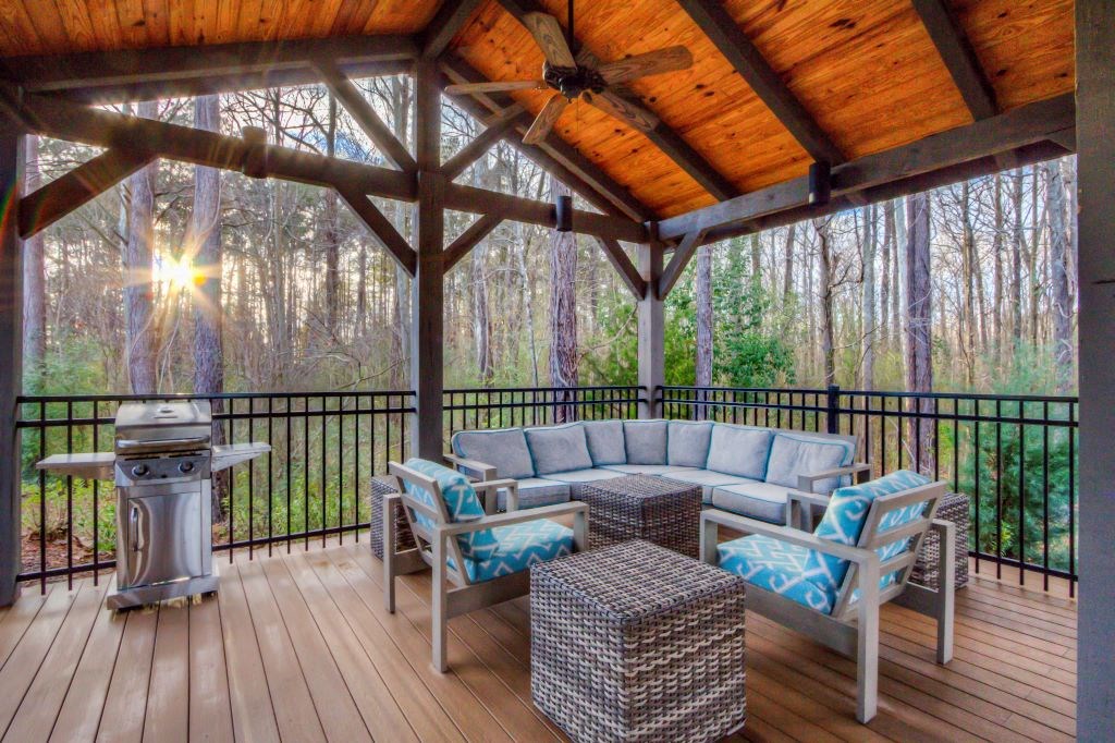 a screened in porch with furniture and a grill